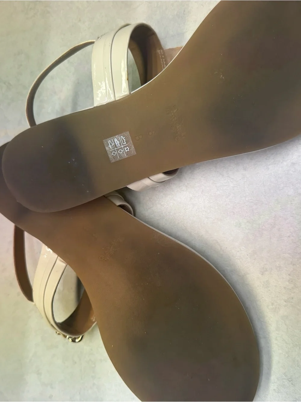 Coach Ivory Patent Leather T‑Strap Sandals with Gold Plaque
